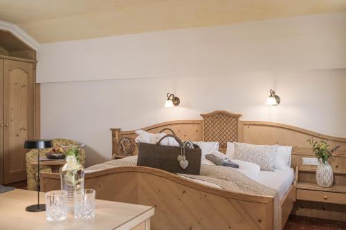 a bedroom with a large bed and a table at Biohotel Rastbichlhof in Neustift im Stubaital