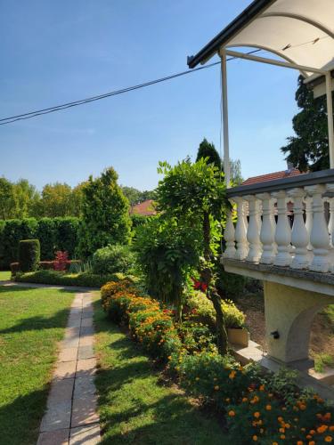 a garden with a white railing and flowers at Green Garden Apartments in Surčin