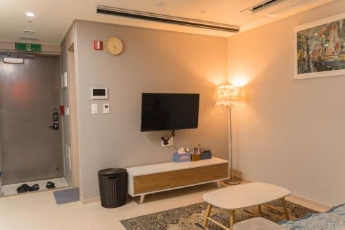 ein Wohnzimmer mit einem TV an der Wand in der Unterkunft KK Stay Ocean view with Netflix in Donghae