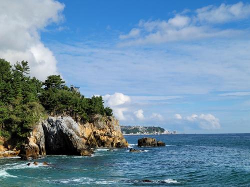 a group of people swimming in the ocean near a cliff at KK Stay Ocean view with Netflix in Donghae