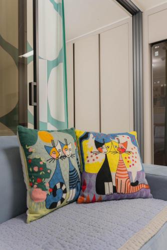 two pillows with cats on them sitting on a bed at KK Stay Ocean view with Netflix in Donghae