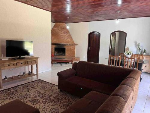 a living room with a couch and a fireplace at Casa de campo com piscina a 2 min de cunha in Cunha