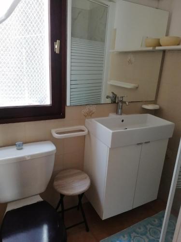 Un baño con lavabo, inodoro y espejo. en Studio bord de mer équipé air conditionné 1min de la plage, en Lumio