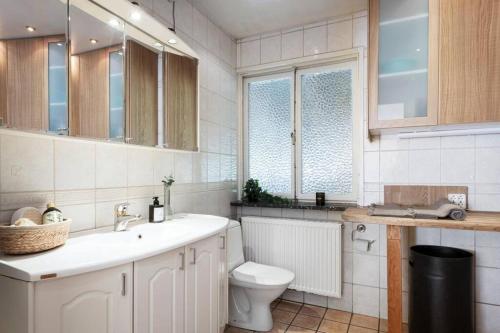 Room in a spacious villa في Stocksund: حمام ابيض مع مرحاض ومغسلة