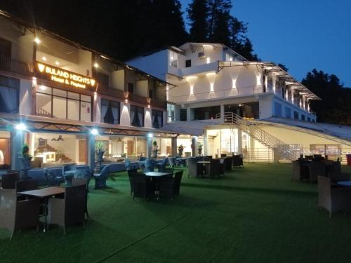 a hotel with tables and chairs in front of a building at BULAND HEIGHTS in Murree