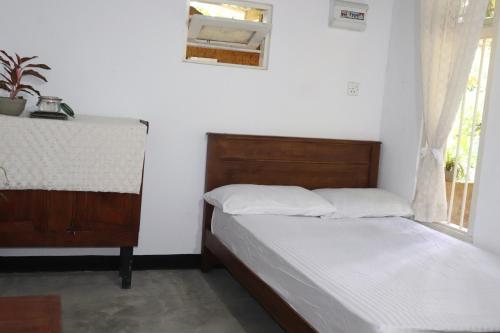 a bedroom with two beds and a window at Yellow Tree Thudugala in Kalutara