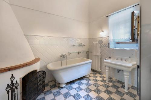 a white bathroom with a tub and a sink at Relais Villa Giusso in Vico Equense