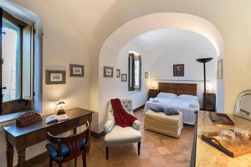a bedroom with a bed and a desk and chair at Relais Villa Giusso in Vico Equense