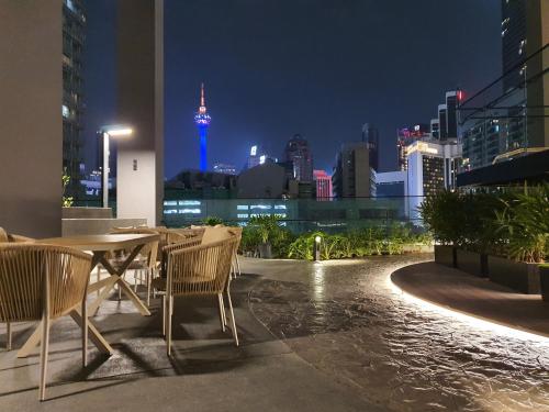 stół i krzesła z widokiem na miasto w nocy w obiekcie 1 min to Pavilion KL Heart of Bukit Bintang by GBS w Kuala Lumpur