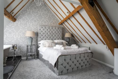 a bedroom with a large bed in a attic at The Loft: Unique, romantic, grade II listed, dog friendly in Stow on the Wold