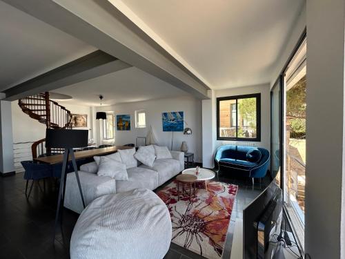 uma sala de estar com um sofá branco e uma cadeira azul em Villa Bord de Mer Accès Plage Presqu'île de Giens-Sea and Mountain Pleasure em Hyères