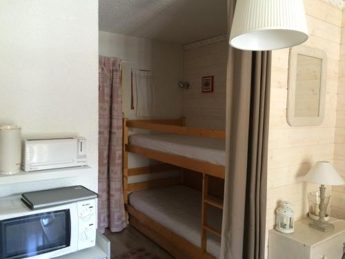 Cette petite chambre comprend des lits superposés et un four micro-ondes. dans l'établissement Studio cabine pour 3 personnes avec balcon Ouest, au centre de Valloire, proche commerces et ski - FR-1-263-461, à Valloire