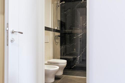 a bathroom with a toilet and a black wall at Trastevere 143 in Rome