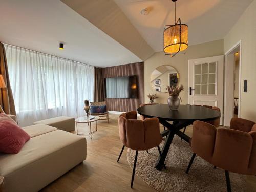 a living room with a table and a couch at Hafen Hotel Schützenhof in Burg auf Fehmarn