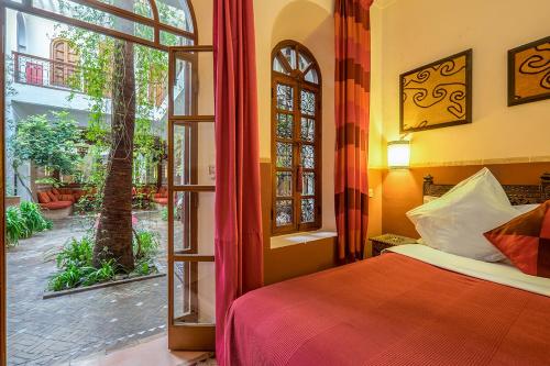 a bedroom with a bed and an open window at Riad Sable Chaud in Marrakesh