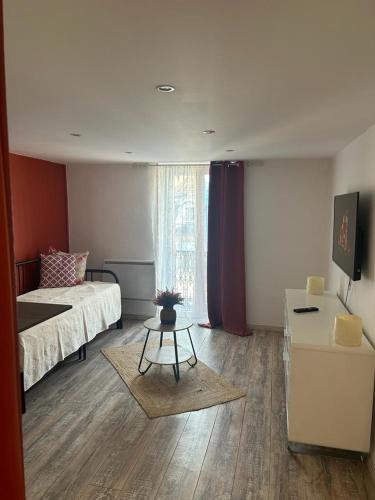 une chambre avec un lit, une table et une fenêtre dans l'établissement Ange appart, à Dijon