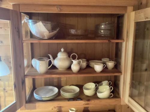 a cabinet filled with dishes and cups and plates at Chalet Spessart in Dammbach