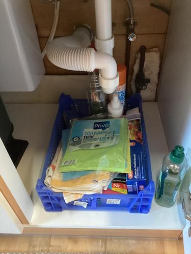 a shelf under a sink with cleaning supplies at Chalet Spessart in Dammbach