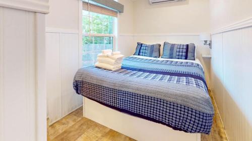 a bedroom with a bed with blue and white sheets at Point Sebago Resort in Casco