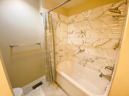 a bathroom with a shower and a tub and a sink at Spanish Style 3-bedroom Home with Hot Tub in Indianapolis