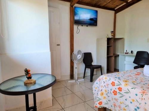 um quarto com uma cama, uma mesa e uma televisão em Bright Bungalow 4 - Close to ocean em Zorritos