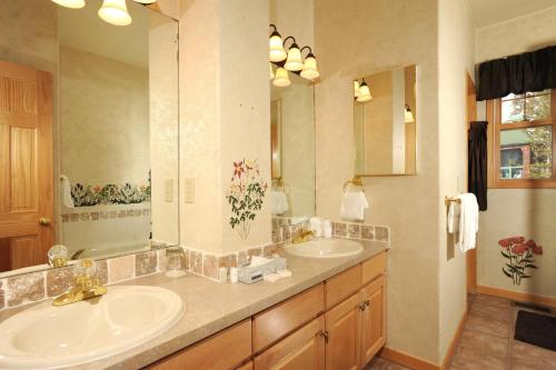 a bathroom with two sinks and a large mirror at The Forest Neighborhood by Keystone Resort in Keystone