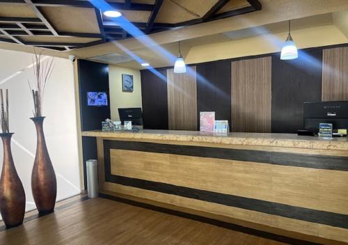 a lobby with a counter with two vases at Ibeurohotel Guadalajara Expo in Guadalajara