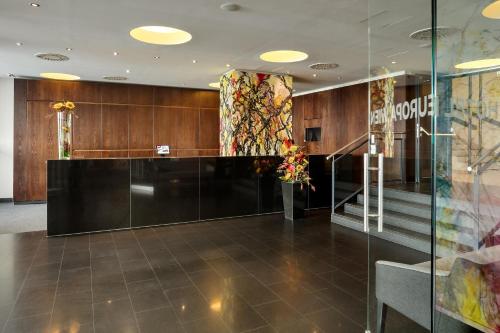 a lobby with wood paneling and a glass wall at Austria Trend Hotel Europa Wien in Vienna