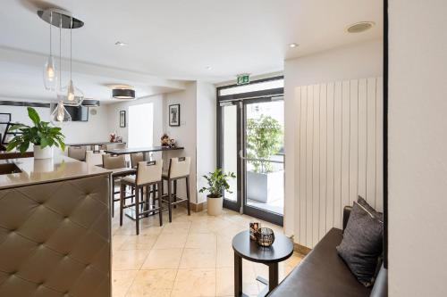 a living room and kitchen with a couch and a table at Hotel Rathauspark Wien, a member of Radisson Individuals in Vienna
