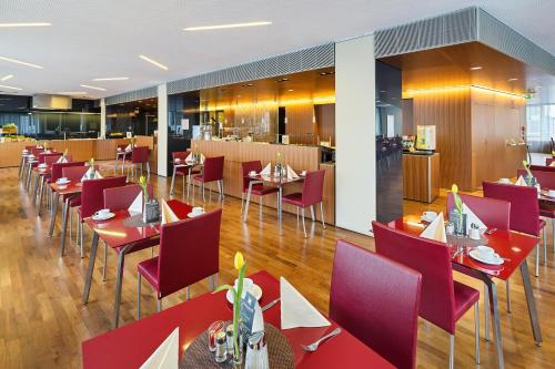 a dining room with red tables and chairs at Austria Trend Hotel Europa Wien in Vienna