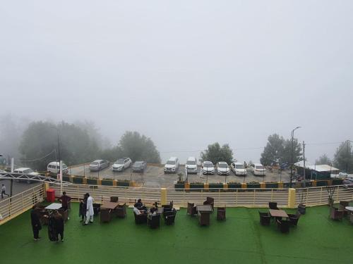 a group of people with horses in a ring with parked cars at BULAND HEIGHTS in Murree