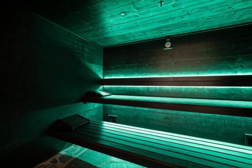 a dark room with a bench with green lights at Mix Brussels --Gym & Wellness for adults only-- in Brussels