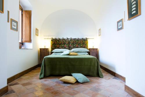 a bedroom with a bed with green sheets and pillows at Relais Villa Giusso in Vico Equense