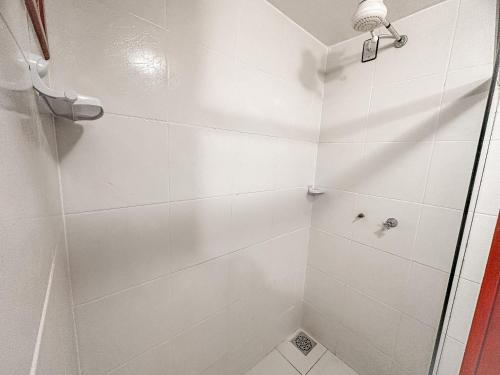 La salle de bains est pourvue d'une douche avec du carrelage blanc. dans l'établissement Com parque aquático, a 200 m praia de Taperapuã e do complexo Axé Mói, suíte para até 4 pessoas, com ar condicionado e frigobar, à Porto Seguro