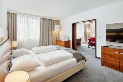 グラーツにあるAustria Trend Hotel Europa Graz Hauptbahnhofのベッドとテレビが備わるホテルルームです。