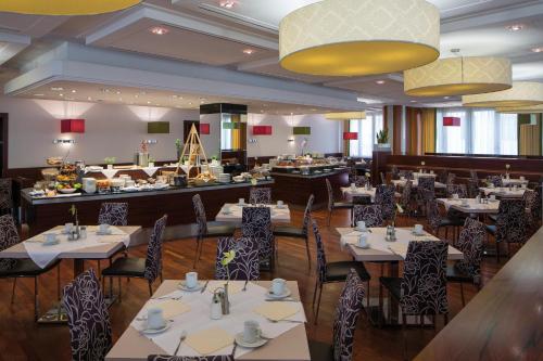 a restaurant with tables and chairs and a bar at Austria Trend Hotel Europa Graz Hauptbahnhof in Graz