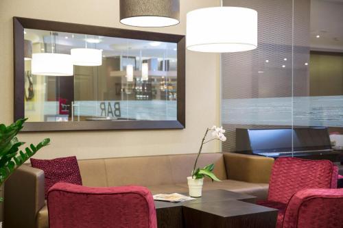 a restaurant with red chairs and a table and a mirror at Hotel Schillerpark Linz, a member of Radisson Individuals in Linz