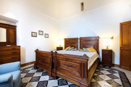 a bedroom with a large wooden bed and a blue couch at Relais Villa Giusso in Vico Equense