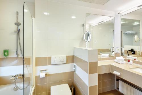 a bathroom with a shower and a toilet and a sink at Hotel Schillerpark Linz, a member of Radisson Individuals in Linz