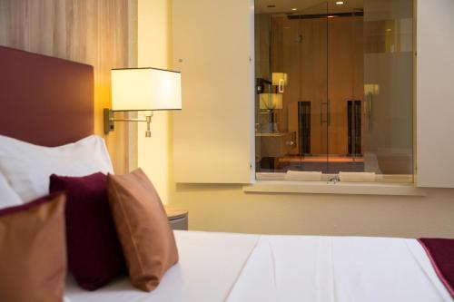 a bedroom with a bed with a window and a mirror at Hotel Schillerpark Linz, a member of Radisson Individuals in Linz
