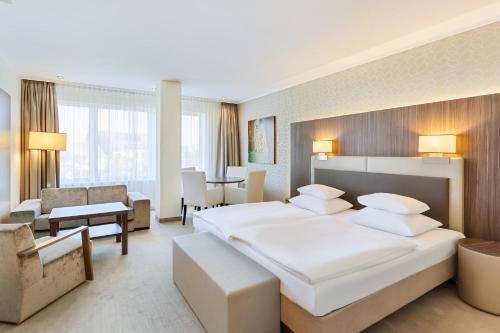 a hotel room with two beds and a living room at Hotel Schillerpark Linz, a member of Radisson Individuals in Linz