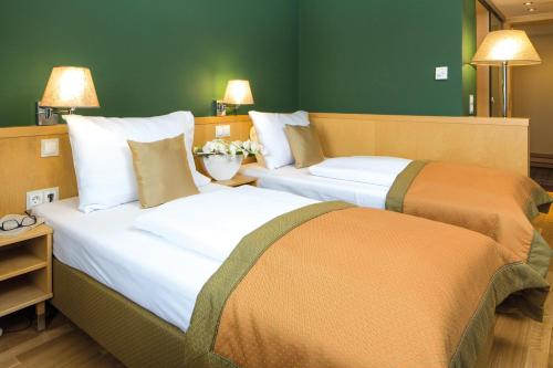 twee bedden naast elkaar in een kamer bij Austria Trend Hotel Ananas Wien in Wenen