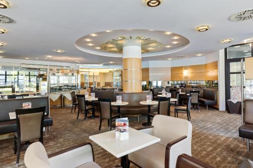 a restaurant with tables and chairs and a bar at Hotel Schillerpark Linz, a member of Radisson Individuals in Linz
