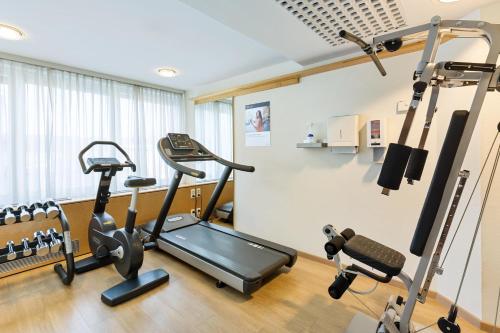a gym with a treadmill and elliptical machines at Hotel Schillerpark Linz, a member of Radisson Individuals in Linz