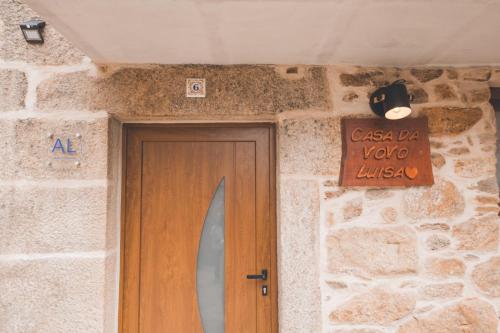 a door in a stone building with a sign above it at Casa da Vovó Luisa in Quinta da Lama Redonda