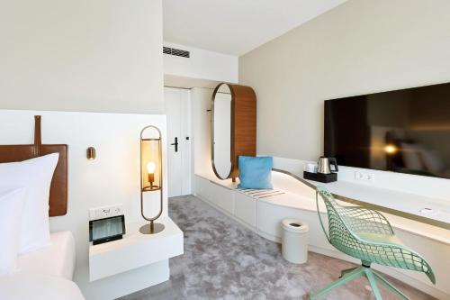 a bedroom with a bed and a mirror and a chair at Austria Trend Hotel Bosei Wien in Vienna