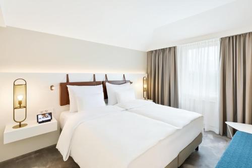 a large white bed in a hotel room at Austria Trend Hotel Bosei Wien in Vienna