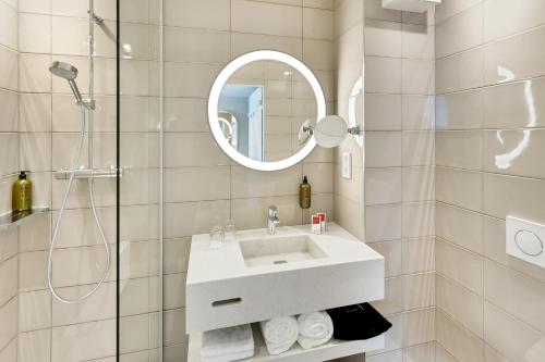 a white bathroom with a sink and a mirror at Austria Trend Hotel Bosei Wien in Vienna