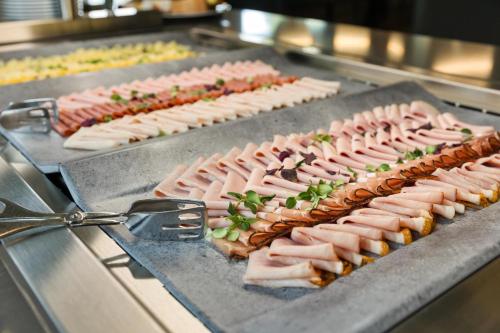 a bunch of different types of meats on a grill at Austria Trend Hotel Bosei Wien in Vienna