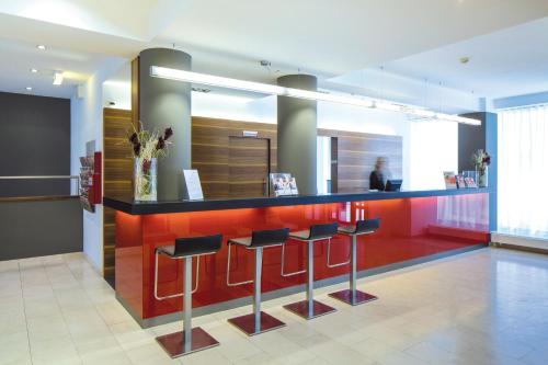 a lobby with a bar with stools in a room at Austria Trend Hotel beim Theresianum Wien in Vienna